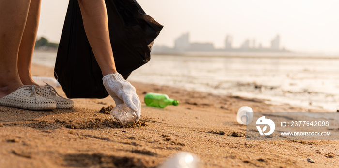 Volunteer woman picking plastic bottle into trash plastic bag black for cleaning the beach, female clean up garbage, Ecology concept and World Environment Day, Save earth concept