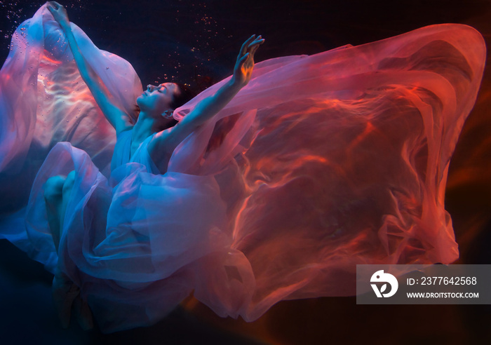 Woman model, ballerina underwater in a fluttering dress. Soft focus.