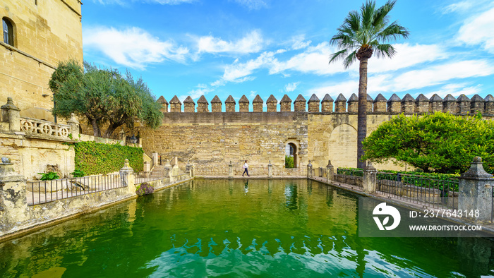 Woman walking in the gardens of the medieval Alcazar of Cordoba, Spain.