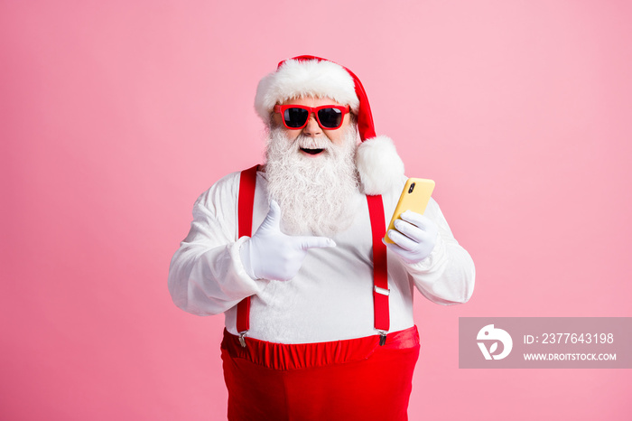 Portrait of his he nice attractive cheerful bearded fat guy Santa using demonstrating device post social network blog media multimedia sale order app 5g isolated over pink pastel color background