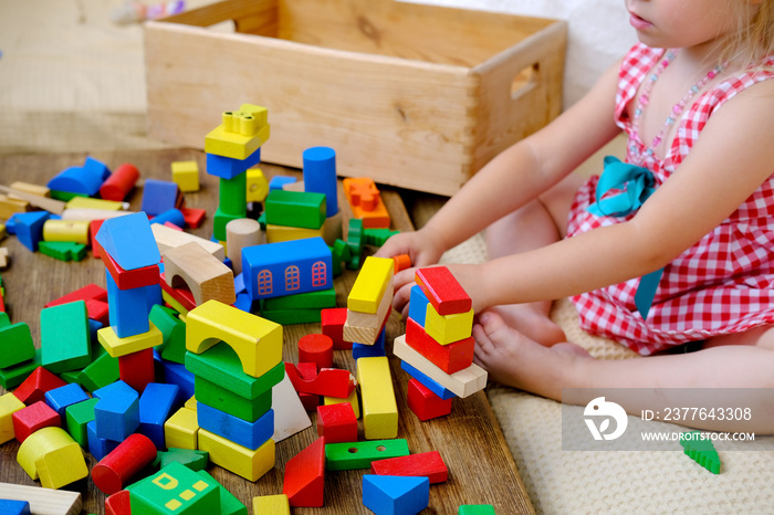 smart little child, girl 3 years old playing with educational toy, wooden geometric figures, blocks, kindergarten games, concept of childhood, earlier child development, creativity, early training