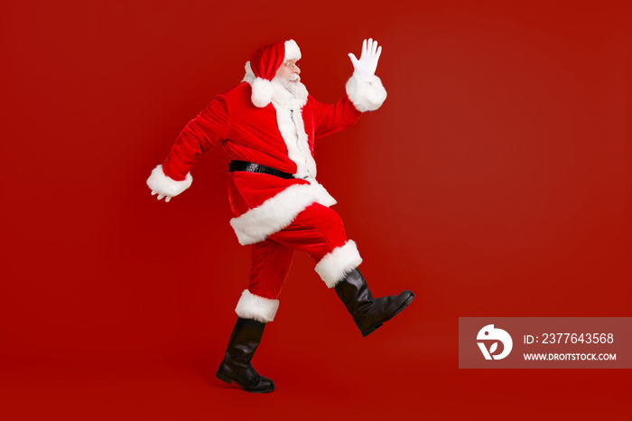 Full length body size profile side view of his he nice funny thick elderly white-haired Santa St Nicholas going having fun making step sale isolated bright vivid shine vibrant yellow color background