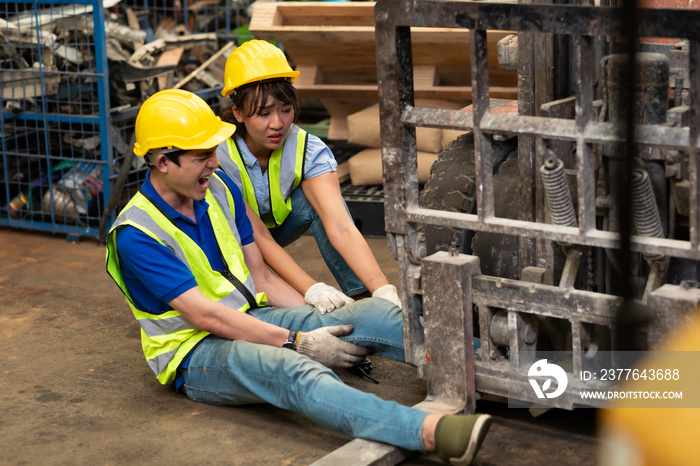 injured Asian man worker after accident in a old car parts warehouse.  Forklift crash leg worker accident