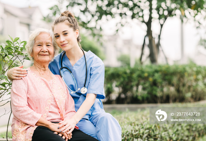 Caregiver with Asian elderly woman outdoor