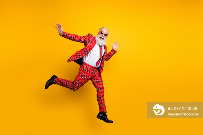 Full length photo of funny hipster grandpa white beard guy jumping high exciting trip wear plaid red blazer tie trousers outfit isolated yellow bright color background