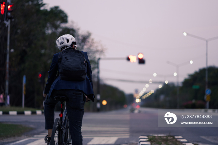 Asian man on a bicycle back from work .He stopped at the traffic lights