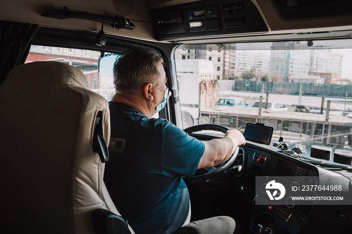 Truck driver inside the cabin with a medical mask on his face