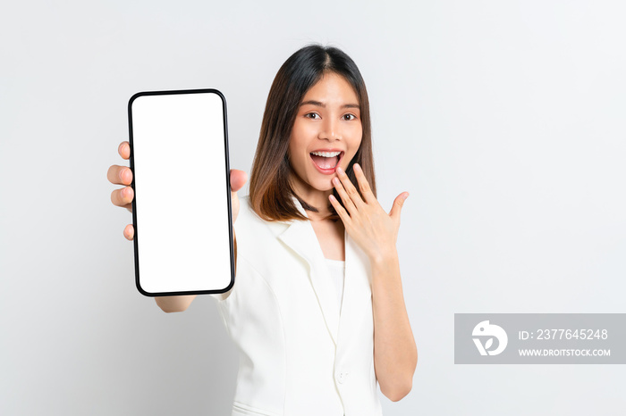 Beautiful Asian woman holding smartphone mockup of blank screen and smiling on white background.