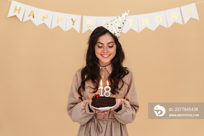 Image of happy young woman smiling while posing with birthday cake
