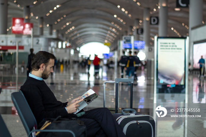 Passenger reading a magazine at the airport