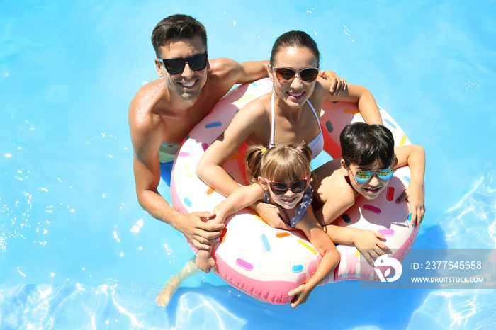 Happy family with inflatable donut in swimming pool