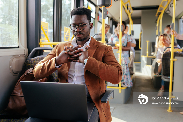 Black man on laptop in public transport