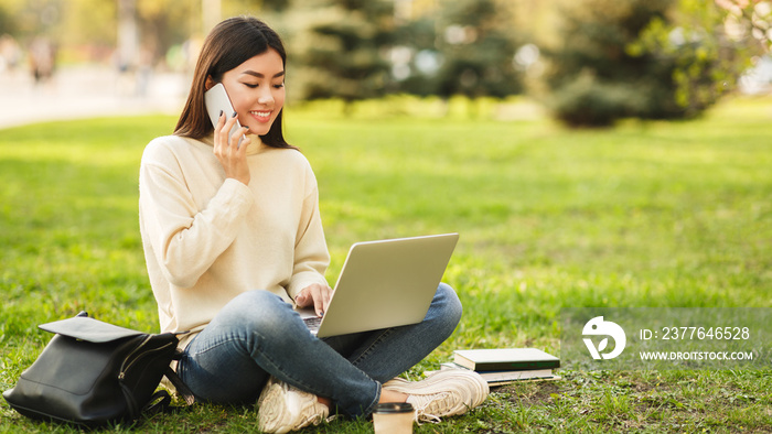 Relax after classes. Happy student sitting in park with laptop