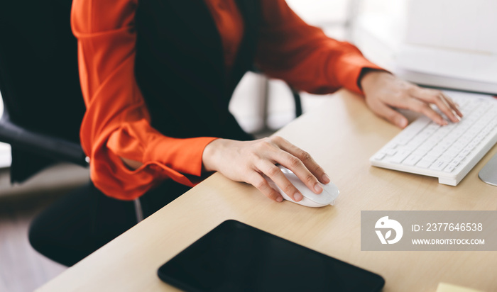 Business woman hand holding mouse using internet computer work in office.