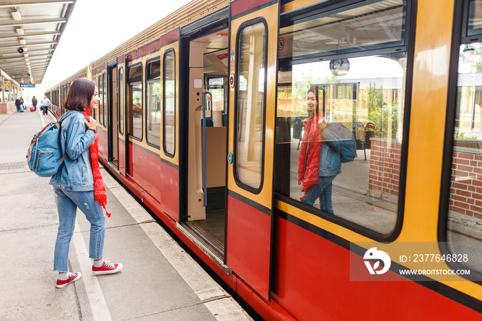 Pretty young tourist woman boarding a train