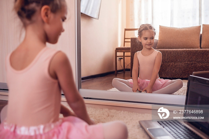 Young ballerina practicing classic choreography during online class in ballet school, self-isolation