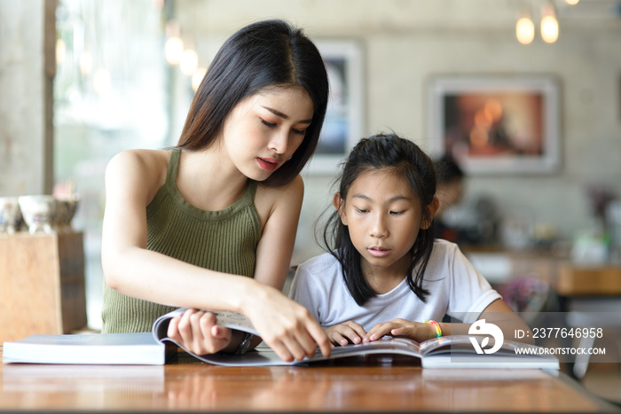 Beautyiful woman reading a book with her younger sister.