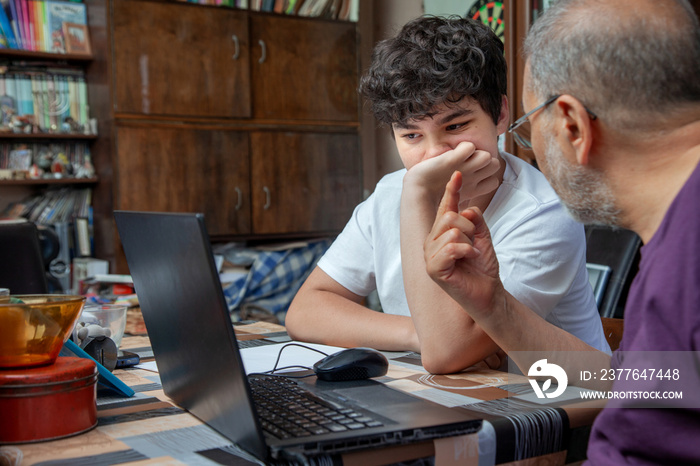 Grandfather is Teaching Lessons to his Teenage Grandson at Home