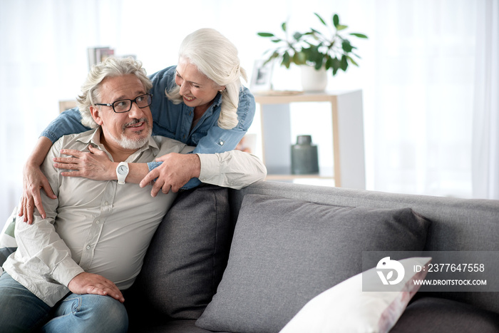 Happy senior loving couple resting in living room