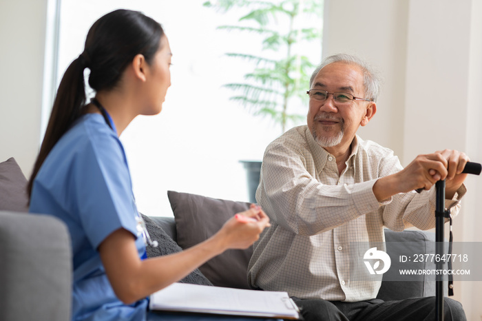 Senior elder man patient talking to caring female doctor physician at nursing home in hospital . Asain doctor explaining well-being get support and have medicare services at medical checkup visit.