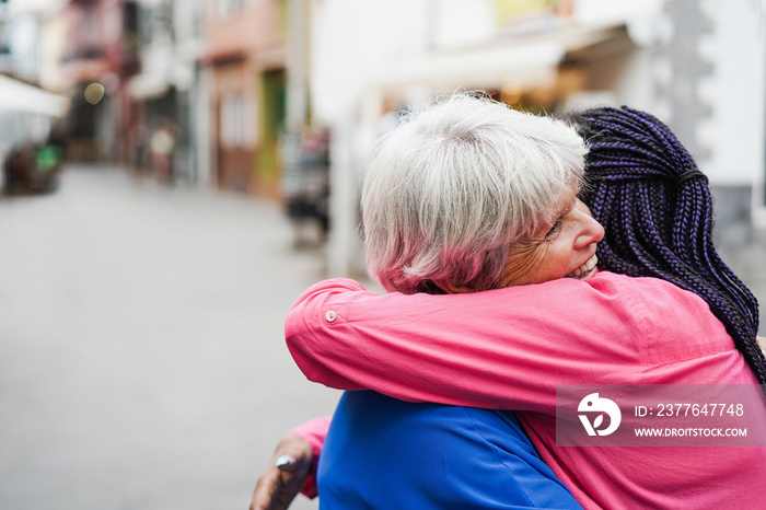 Senior multiracial women meeting and hugging each others outdoor - Focus on female eye