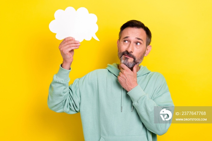 Photo of intelligent man hold white paper cloud bubble interested look empty space offer proposition isolated on yellow color background