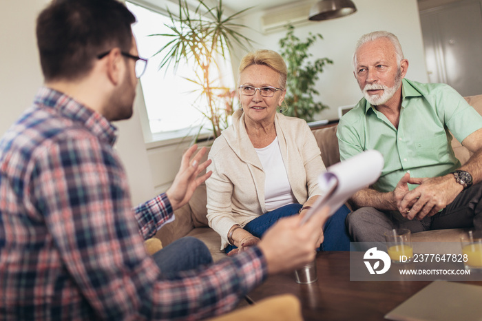 Positive aged couple consulting with insurance agent