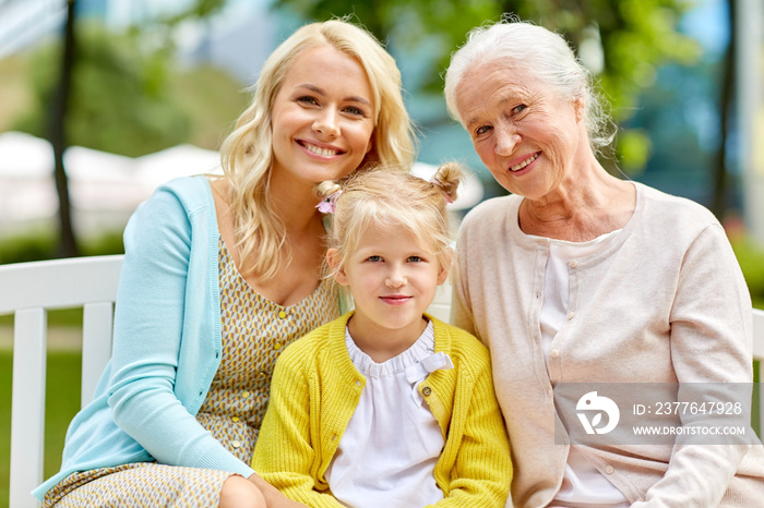 family, generation and people concept - happy smiling woman with daughter and senior mother sitting on park bench