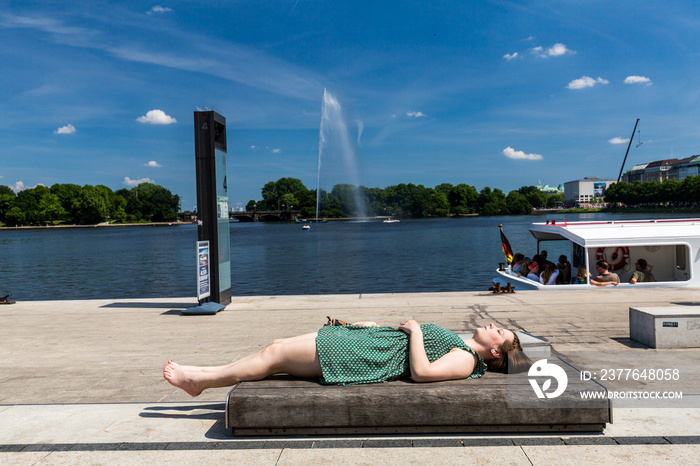 Girl lying on a bench at the Jungfernstieg in Hamburg, Germany