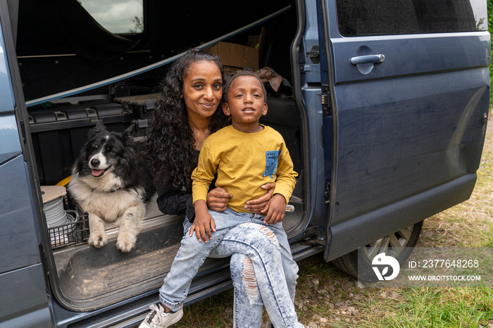 Portrait of mother with son and dog in van preparing for trip