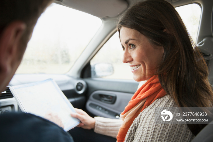 Mature woman holding map in car