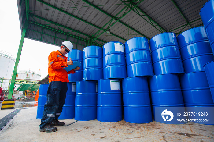 Male worker inspection record drum oil stock barrels blue horizontal or chemical