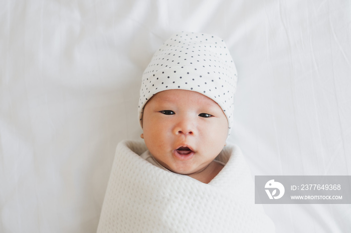 Portrait Asian newborn baby in white cloth on bed