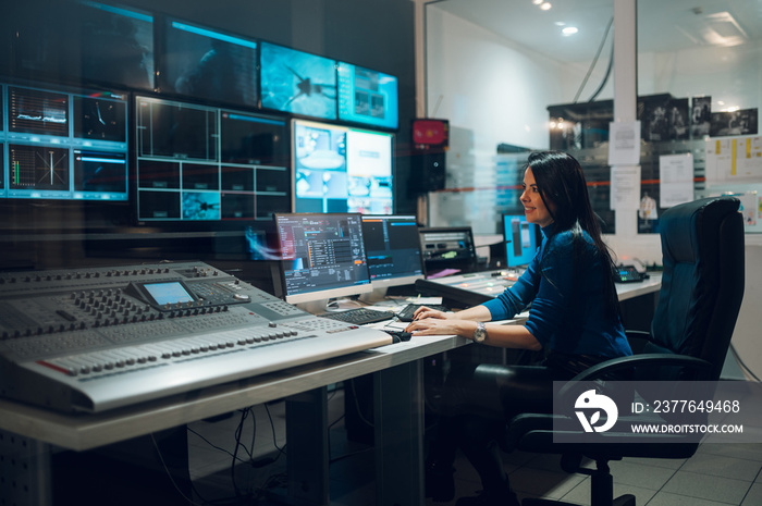 Middle aged woman using equipment in control room on a tv station