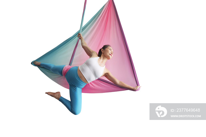Mature woman pose in hammock performing aerial yoga or flying yoga exercise isolated on white background. Healthy lifestyle and emotional health of middle aged people
