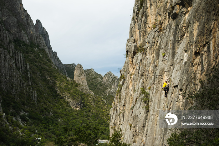 Rock climber scaling a mountain in a Mexican valley.