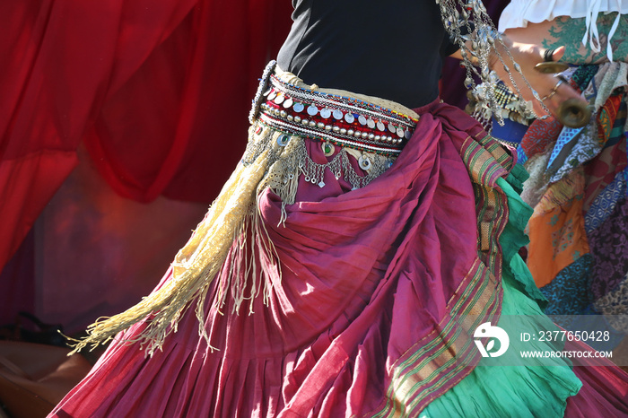 Elements of clothing for a gypsy dance, a scarf at the waist, a belt with a monist, a dancing woman