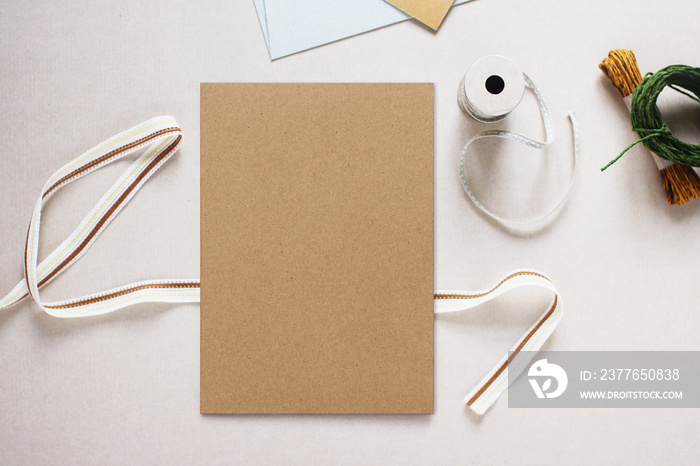 Mockup image of Brown Paper Invitation Card. Surrounded by Craft Equipment, Flat Lay Design, Vintage Style, Top View