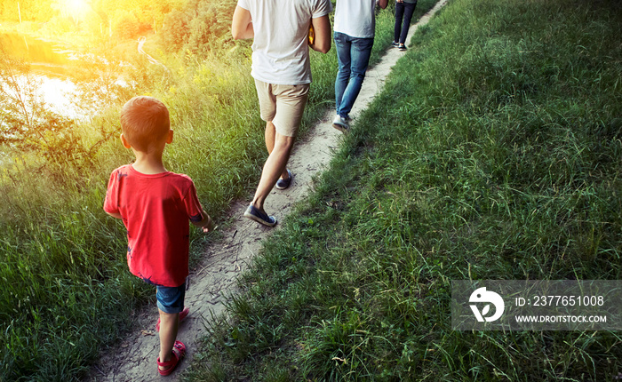 The friends are walking through the pathway on the hill