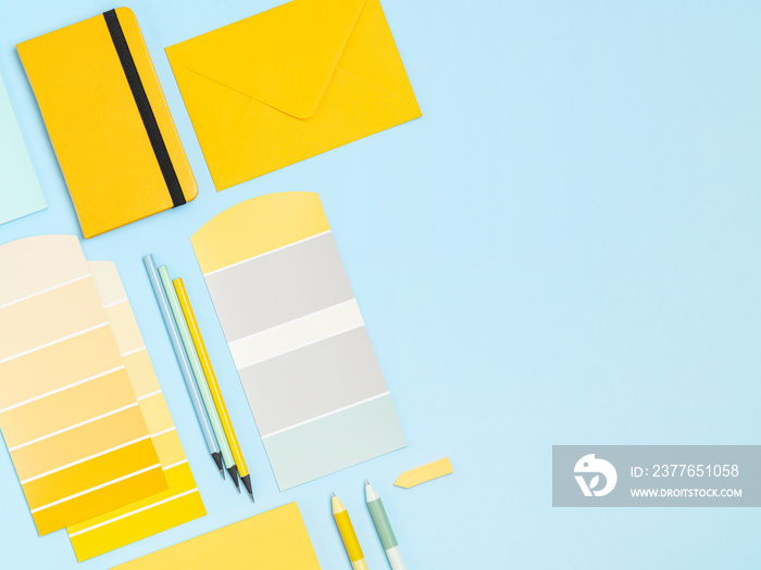 Simple, bright and colourful artists, designers workplace background with place for text. Colour samples palette, notebook, pens, pencils frame for people of creative professions and students.