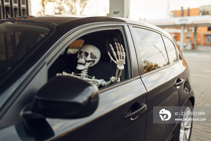 Skeleton in car, fueling on gas station