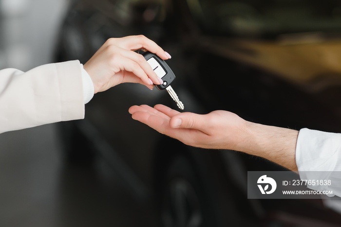 businessman exchange handing over the car keys for to a young women.