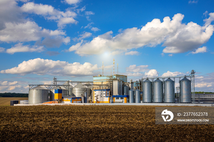 Agricultural Silos. Storage and drying of grains, wheat, corn, soy, sunflower against the blue sky with white clouds.Storage of the crop