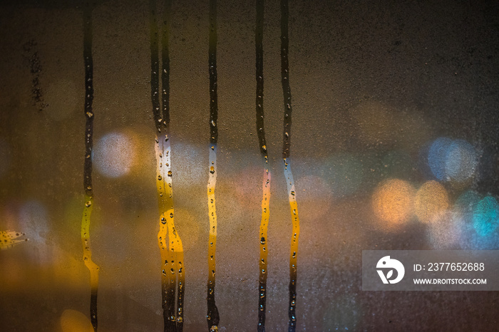 smudges on the frozen glass, misted glass, night lights bokeh on background