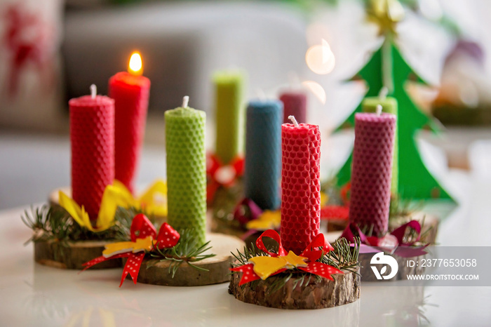 Close shot of natural handmade candles made of beeswax on a wood with christmas decoration