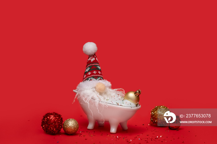 Dwarf Santa in the bathroom on red background. Creative Xmas or New Year celebration party concept