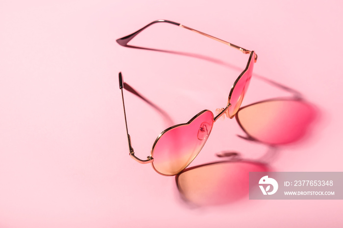 Stylish sunglasses on color background