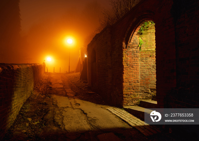 Harrow on the Hill pathway at night with fog and warm streetlights, England