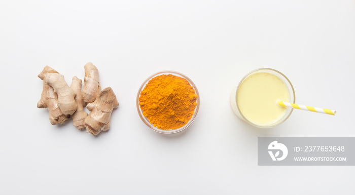 Turmeric powder and ginger root on white background