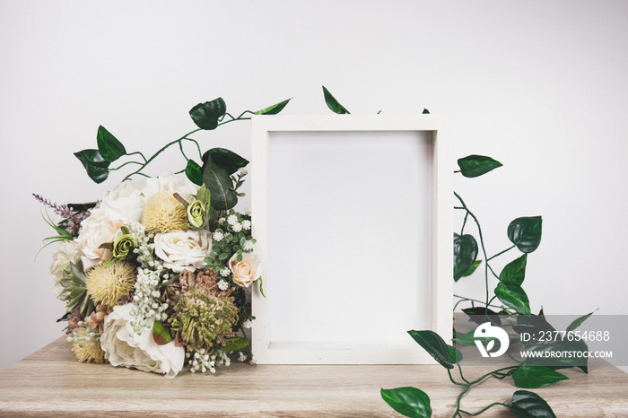 White frame mockup with flower and vine.